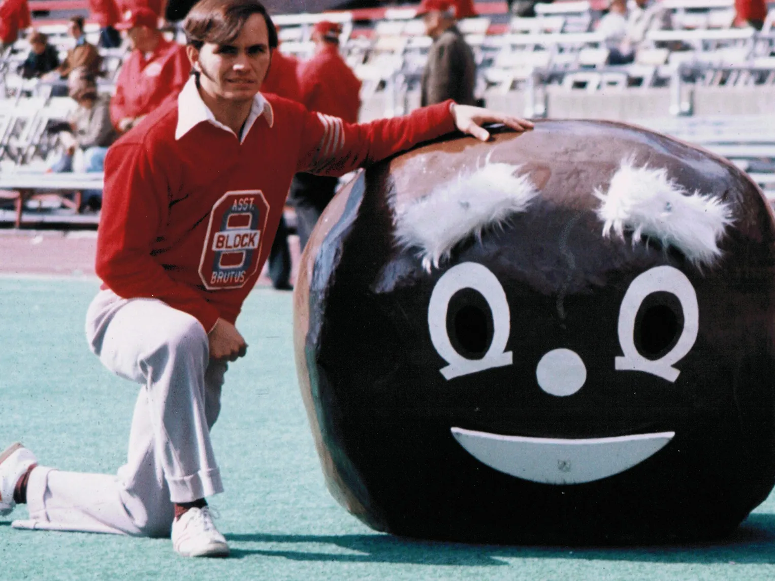 In his college days, Lester Cline was a built young man with chestnut colored hair. He poses on a sunny day inside Ohio Stadium, kneeling on one leg and posing with his hand on the giant Brutus Buckeye head he would have worn. It’s probably almost 4 feet wide and must have been heavy. It has a smiley face on it with bushy eyebrows.