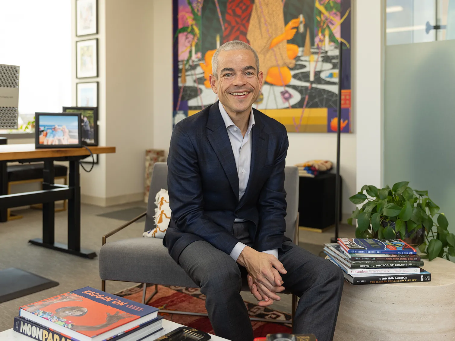 Matt Scantland smiles as he poses for a portrait in his office. He&#039;s a thin, white, middle age man with close cropped hair wearing a sport coat. His smile is genuine.