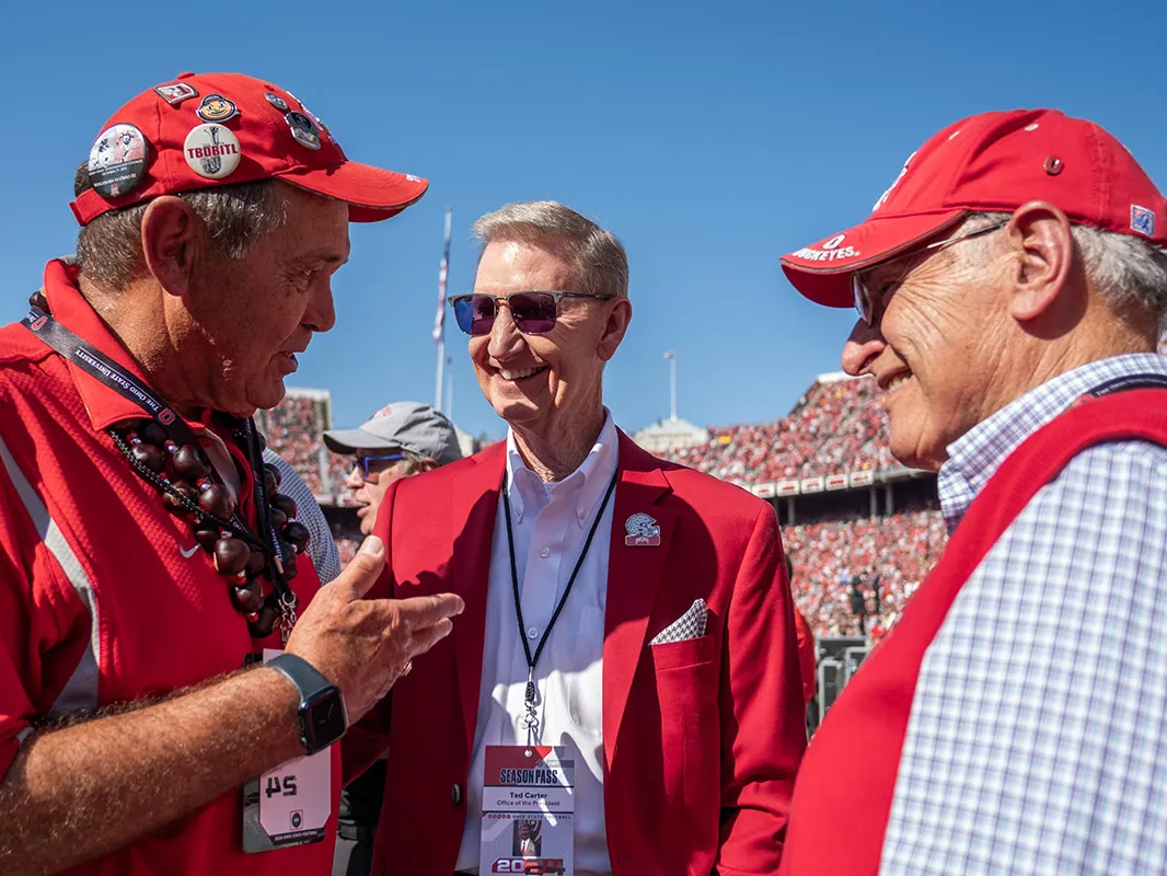 President Carter is flanked by two Ohio State alumni at a football game