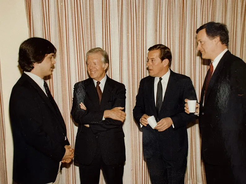 Four white men in suits are shown in this 1984 photo. On the left is a student; seriously listeninng to him talk are former president Jimmy Carter, Ohio State's president and Ohio's governor.