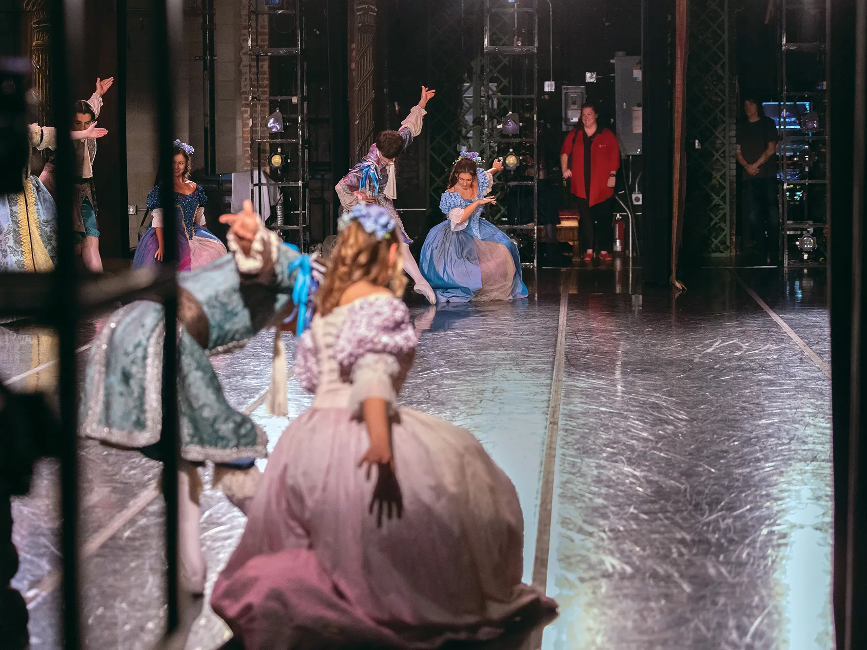 Ballet dancers practice on stage while in the wings opposite of where the photographer stood, an Ohio State athletic trainer watches how comfortably they move.
