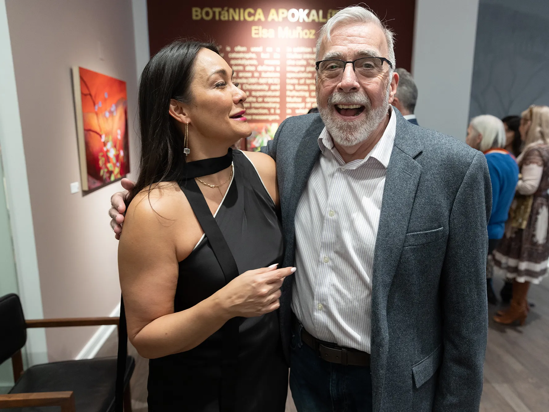 Michelle Brandt and Duff Lindsay laugh as they stand with arms around each other. Their amusement feels genuine and comfortable.