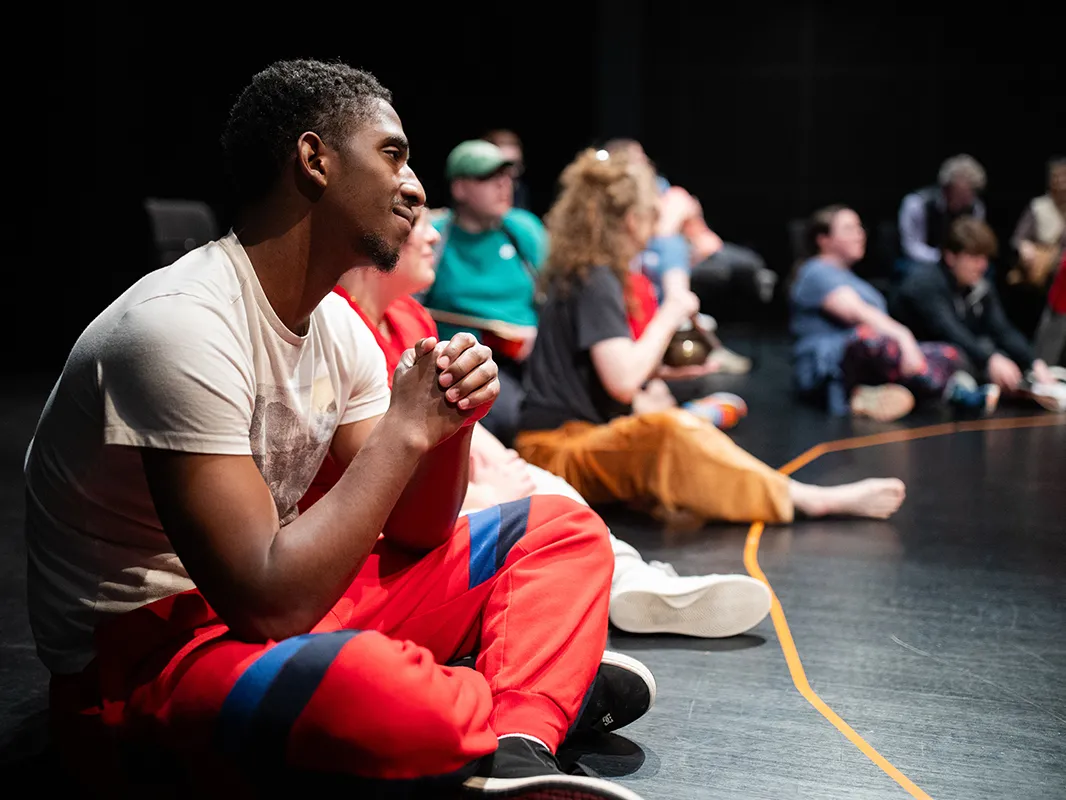 Sitting on the floor of an auditorium in a big circle are a young Black man and others with autism, as well as ohio state students. They&#039;re getting ready to participate in a special Shakespeare and Autism program