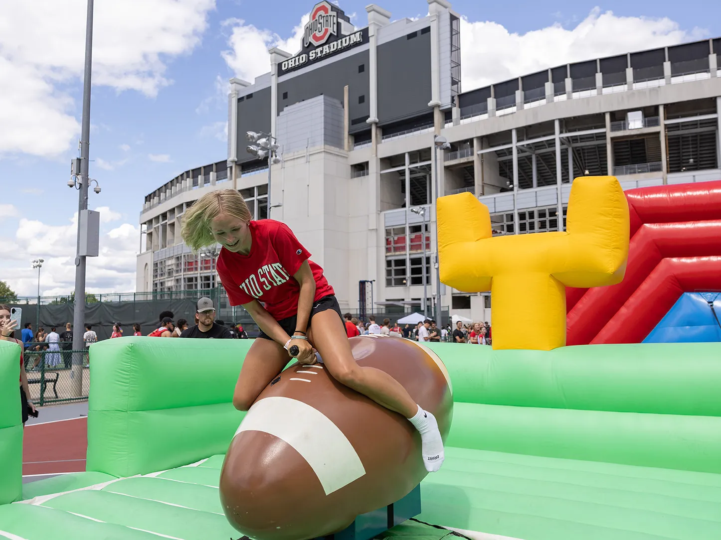 During welcome week, a first year student rides a football like a bucking bronco.