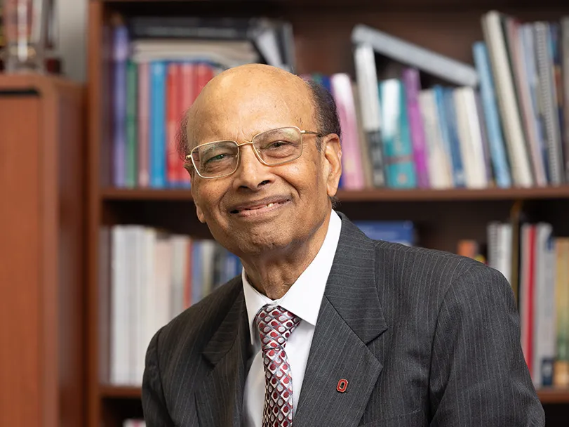 Milap Nahata, a professor who grew up in India, smiles as he poses for this photo wearing a suit and glasses. He looks intelligent and friendly.
