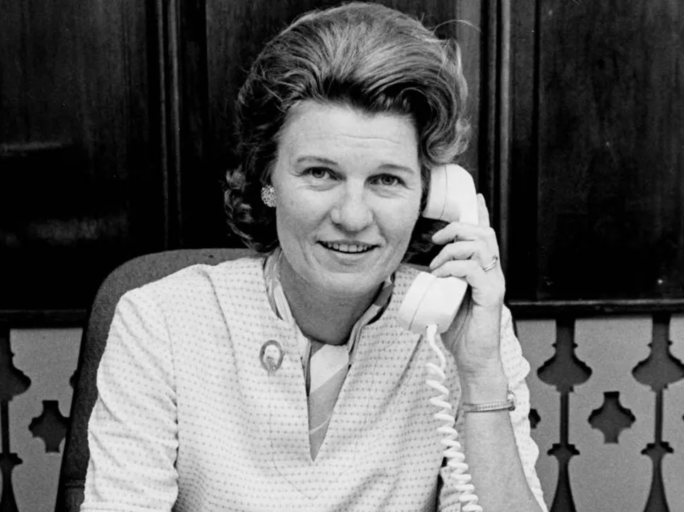 A young Dorothy Teater smiles for the camera as she speaks on an old rotary style telephone.