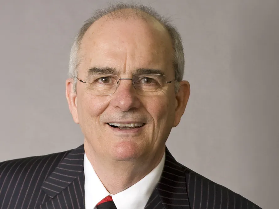 Gregory Williams wears glasses, a suit and an open mouthed smile. He looks like he&#039;s laughing as he poses for this formal portrait.