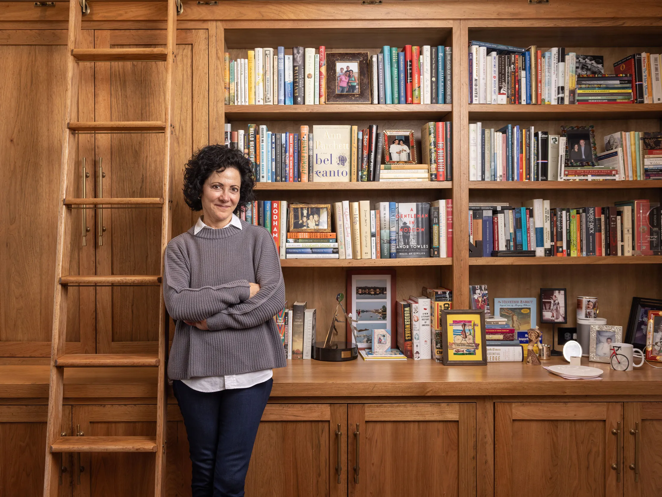 Linda Kass smiles as she leans against shelving packed full of books in her home study. It has a woody, homey feel--classic yet elegant and casual at the same time-just like Linda herself. She's a small-framed woman with dark curly hair and a mischievous expression.