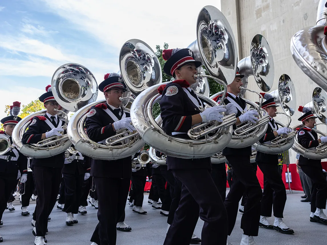 The Ohio State Marching Band carries their instruments while marching into Ohio Stadium.