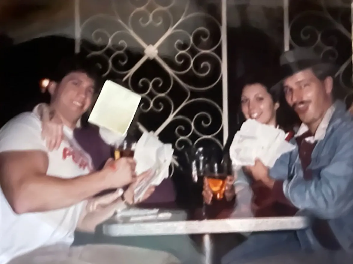 Four college students sit at a restaurant table grinning.