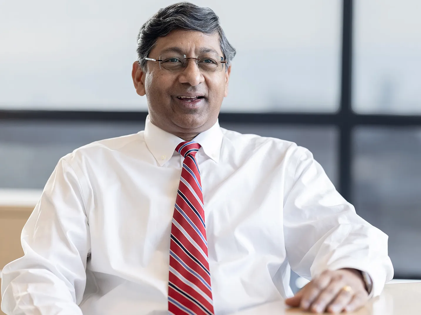 Ravi Bellamkonda smiles as he sits at a table