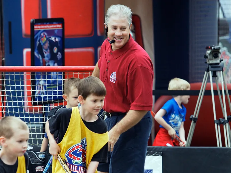 Bill Davidge smiles as he watches kids play hockey.