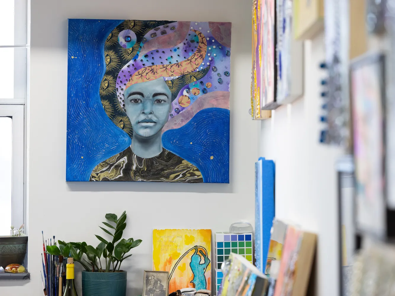 A photo of one of Sunami's portraits shows a woman with colorful bands of patterns as her hair. She stares straight you