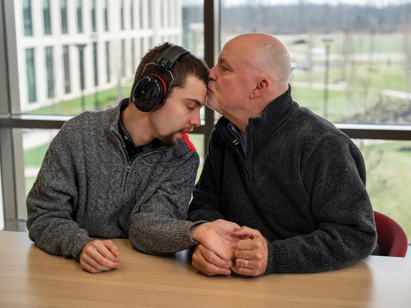 A father kisses his son on the forehead.