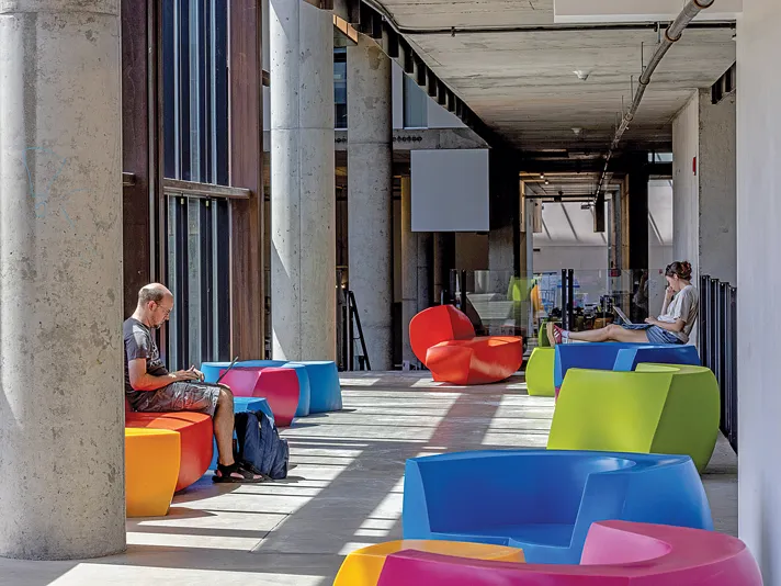Colorful chairs in modern shapes line a student study place inside the school building