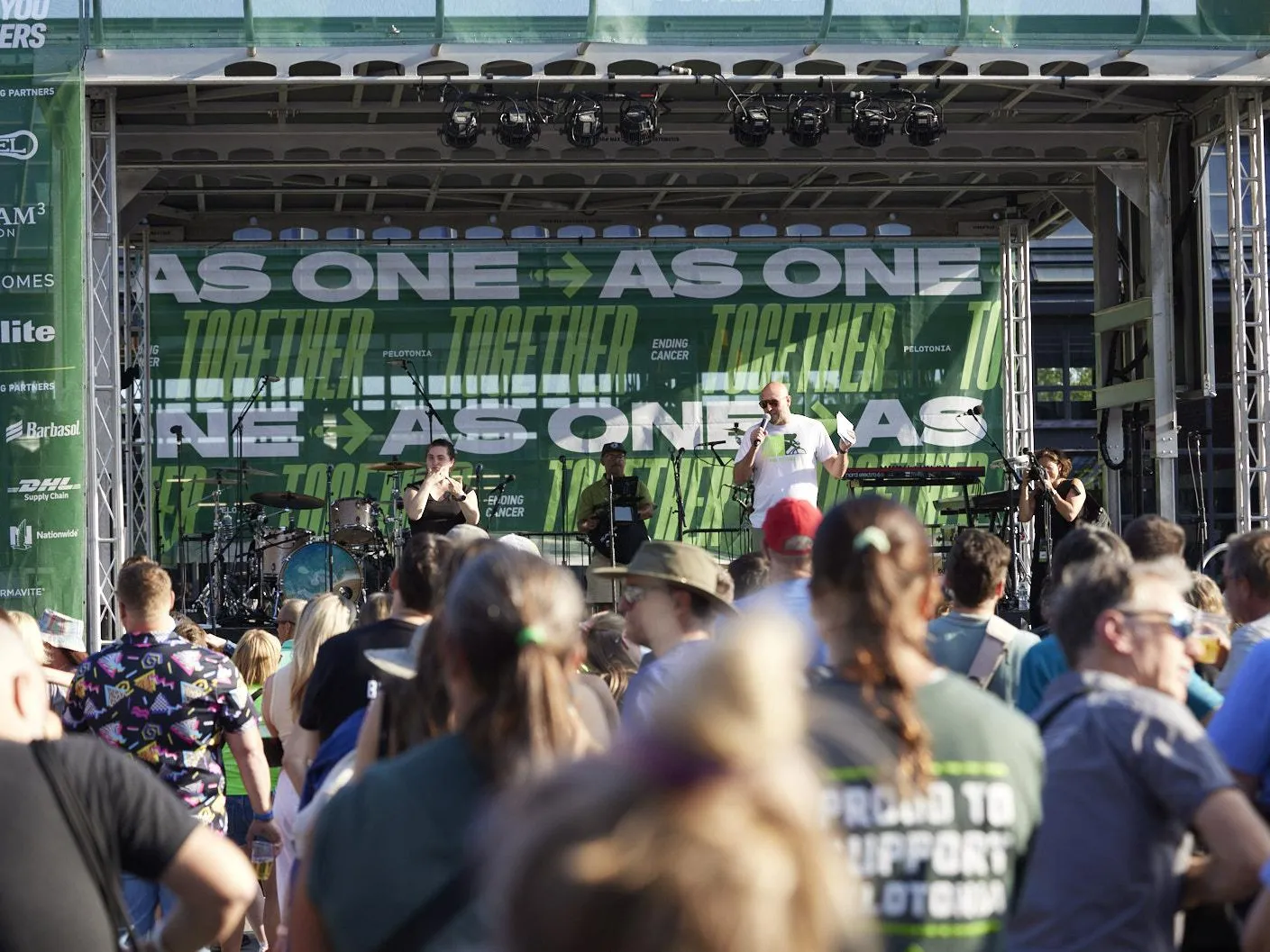 People gather in front of a stage.